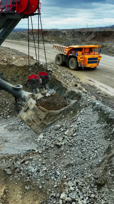 Material loading process with synchronized truck and excavator movement under Stock Footage 321970863