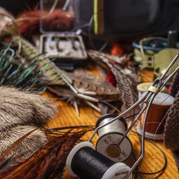 Materials and tools for tying lures on a wooden table. Fly Fishing Still Life Stock Photos