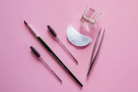 Materials for depilation of eyebrows on a pink background. Wooden stick for w Foto stock