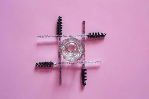 Materials for depilation of eyebrows on a pink background. Wooden stick for w 库存照片