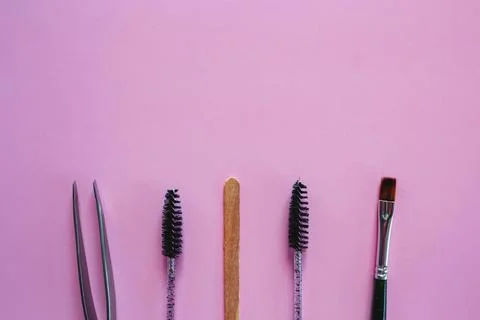 Materials for depilation of eyebrows on a pink background. Wooden stick for w Stock Photos
