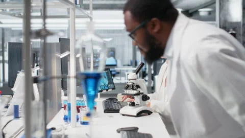 Materials scientist operating compound microscope, studying genetic disorders Stock Footage 320143761