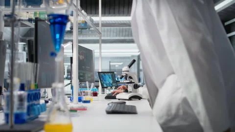 Materials scientist operating compound microscope, studying genetic disorders Stock Footage 320724004