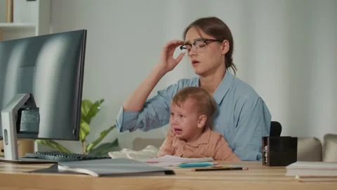Maternity Leave and Parental Support. Mother Struggles to Work at Computer While 库存影片 318361788