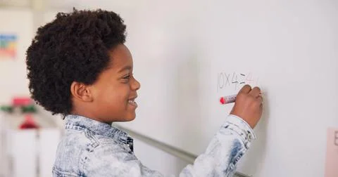 Math class, happy child at board for education, learning and problem solving for Foto stock