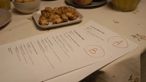 Math Exam Papers with Excellent Grades on Dinner Table with Food at Home Stock Footage 335308946