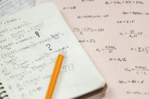 Math formulas are written in pencil on a piece of paper, math problems Stock Photos