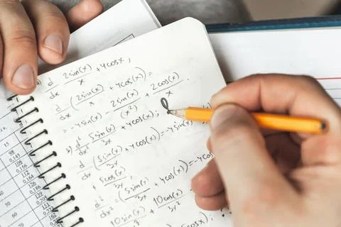 Math formulas are written in pencil in a notebook holding man in Stock Photos