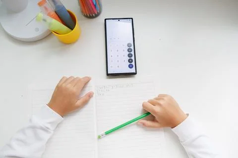 Math homework with a smartphone calculator. Using a mobile phone to solve mat Stock Photos