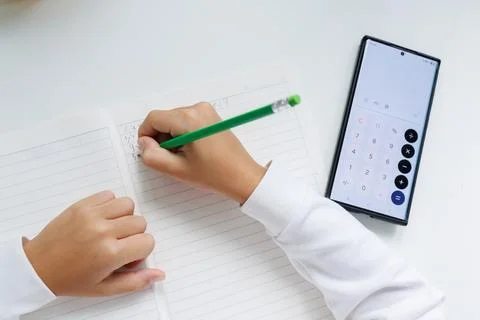 Math homework with smartphone calculator. Using a phone to calculate numbers, Stock Photos