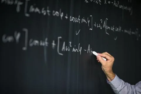 Math teacher by the blackboard during mathclass  Stock Photos