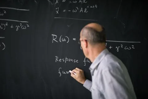 Math teacher drawing   fuction graph on a blackboard during mathclass (shallo Stock Photos