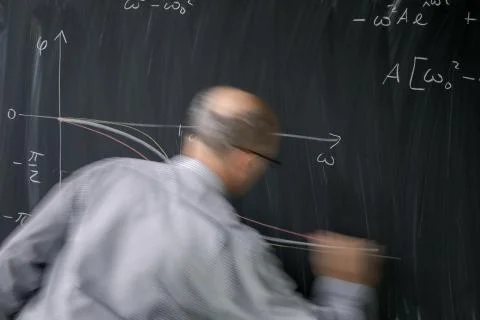 Math teacher drawing   fuction graph on a blackboard during mathclass  Stock Photos