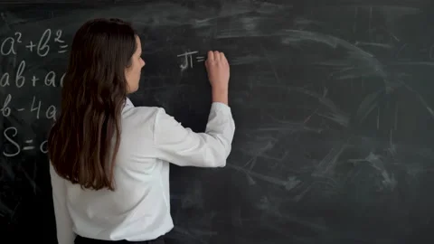 Math teacher writing equation or function on blackboard in school classroom Stock Footage 152327866