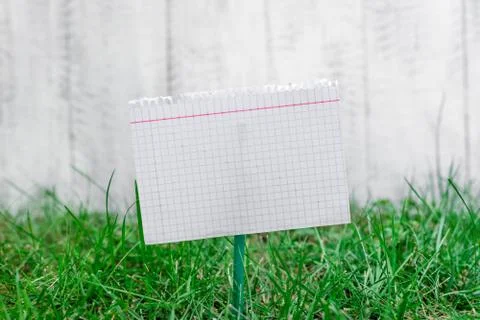 Mathematic paper attached to a stick and plugged in the grassy land. White math Stock Photos