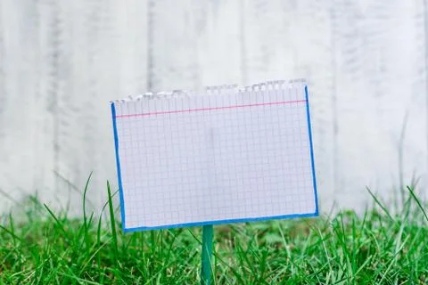 Mathematic paper attached to a stick and plugged in the grassy land. White math Stock Photos