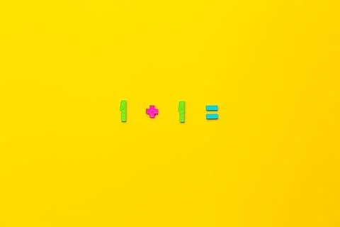 Mathematical example one plus 1 is equal on yellow background Stock Photos