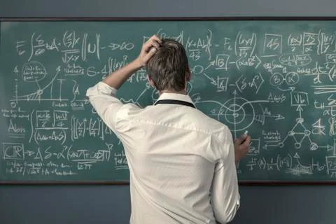 Mathematician solving problems and writing formulas on the chalkboard Foto stock
