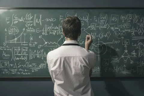 Mathematician solving problems and writing formulas on the chalkboard 写真素材