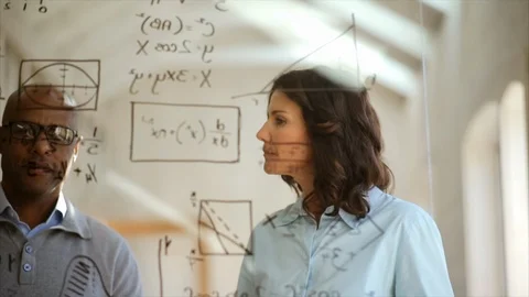 Mathematicians working on equations together. Stock Footage 88406122