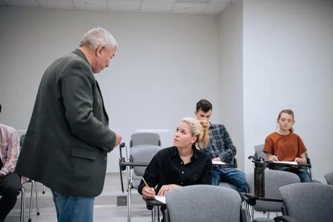 In a mathematics class at the university, an elderly professor approaches Stock Photos