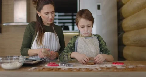 Mather have fun with son on kitchen. They preparing Christmas cookiesand pours Stock Footage 169822085