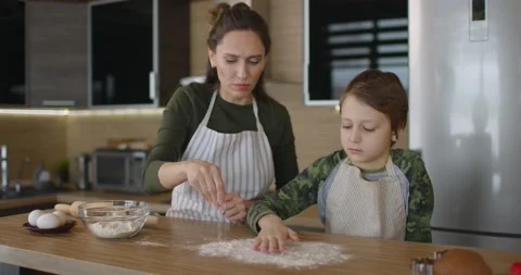 Mather have fun with son on kitchen. They preparing Christmas cookiesand pours Stock Footage 169822258