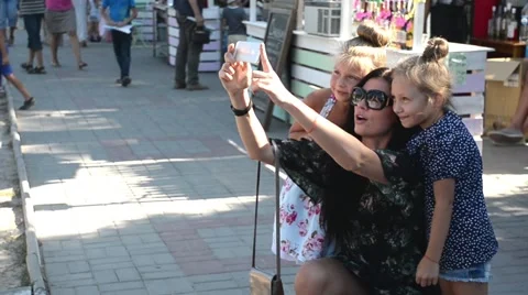 Mather with her daughters making self photo on the street Stock Footage 54325121