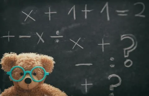 Maths concept. Smart kid in school class, cute teddy wearing blue eyeglasses Foto stock