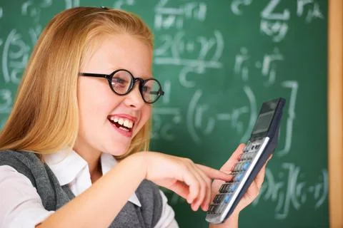 Maths is easy when you use your calculator. A cute blonde girl adding on her 스톡 사진