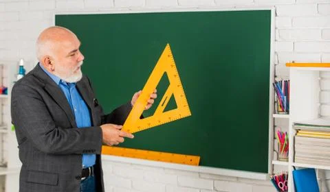 Maths Problem Solving. senior man teacher use math triangle tool. bearded tutor Stock Photos