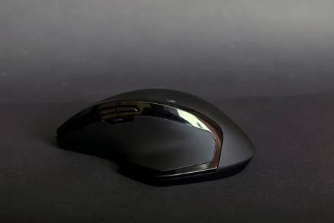 Matte black wireless computer gamer mouse on black paper textured background. Stock Photos