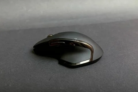Matte black wireless computer gamer mouse on black paper textured background. Stock Photos