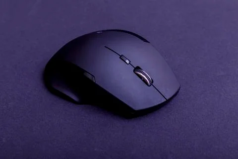 Matte black wireless computer gamer mouse on black paper textured background. Stock Photos