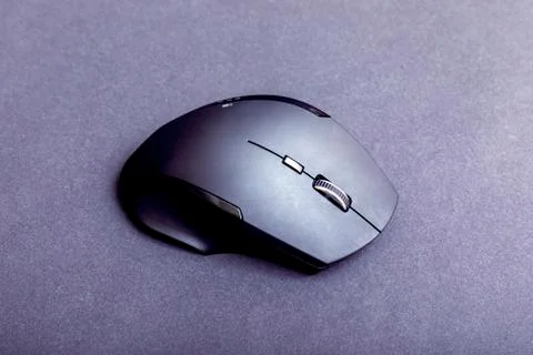 Matte black wireless computer gamer mouse on black paper textured background. Stock Photos