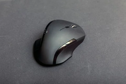 Matte black wireless computer gamer mouse on black paper textured background. Stock Photos