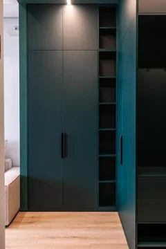 Matte teal wardrobe with built-in open shelves Stock Photos