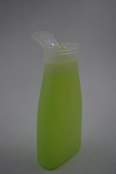Matte white bottle, transparent cap with toxic green, yellow liquid gel. Stock Photos