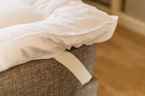 A mattress topper is placed on a sofa to create a soft surface for sleeping.. Stock Photos