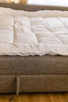 A mattress topper is set on the sofa to create a cozy sleep space. This set.. Stock Photos