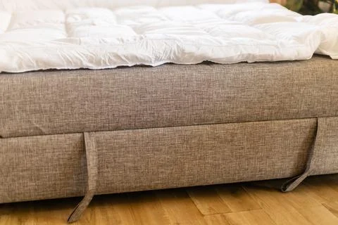 A mattress topper is set on the sofa, creating a sleeping space on the couc.. Stock Photos