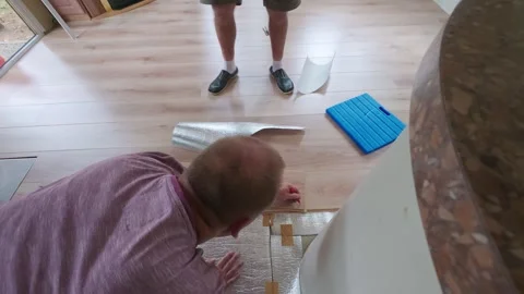 Mature and senior men installing laminate flooring in a tiny house renovation 스톡 동영상 341634873