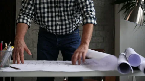 Mature architect or engineer open blueprint on the desk in office Stock Footage 231487746