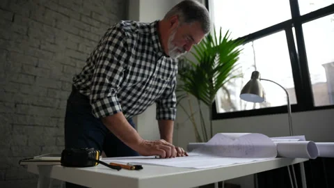 Mature architect or engineer open blueprint on the desk in office Stock Footage 231488096