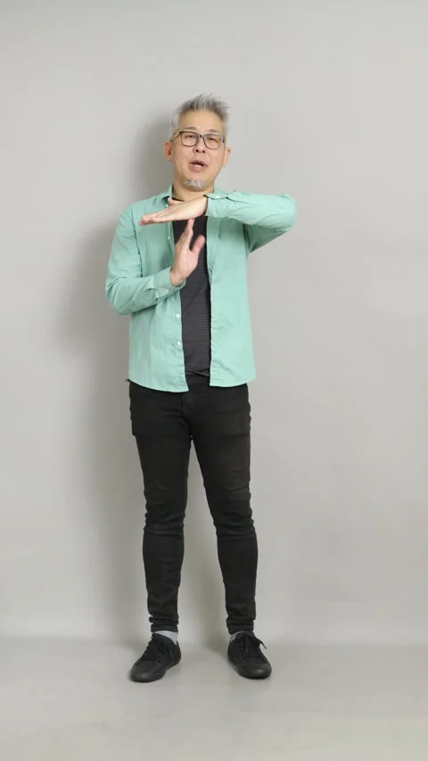 Mature Asian man making a "T" timeout hand gesture to signal a break or stop in  Stock Footage 332846772