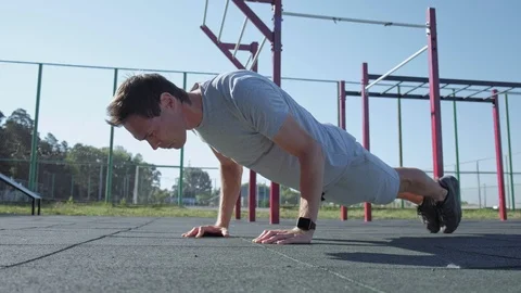 Mature athlete doing push-ups wearing smartwatches. 库存影片 95232033