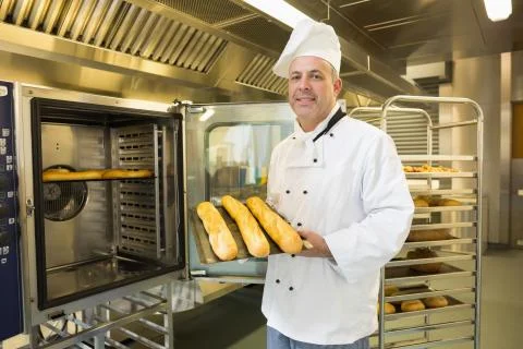 Mature baker showing three baguettes Stock Photos