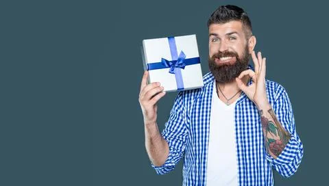 Mature bearded guy with present box on grey background. ok Stock Photos