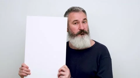 Mature bearded man pointing on white sign, thumbs up, approves choice Stock Footage 147996208