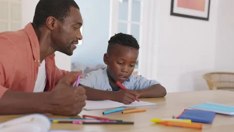 Mature black father helping son with homework Stock Footage